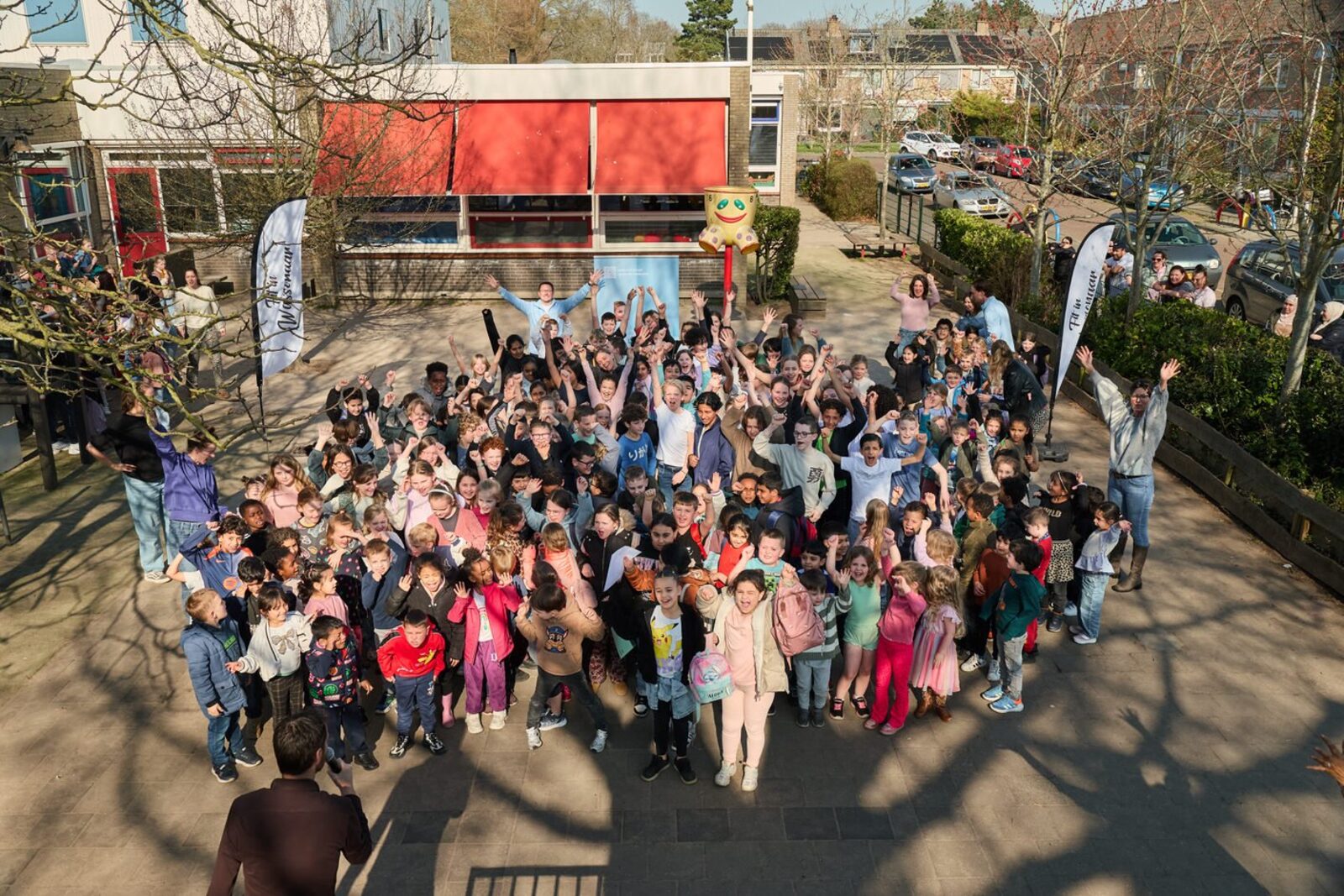 Eerste Lentedag Wassenaar 2026: alle leerlingen verzameld op het schoolplein bij de FiW-vlaggen