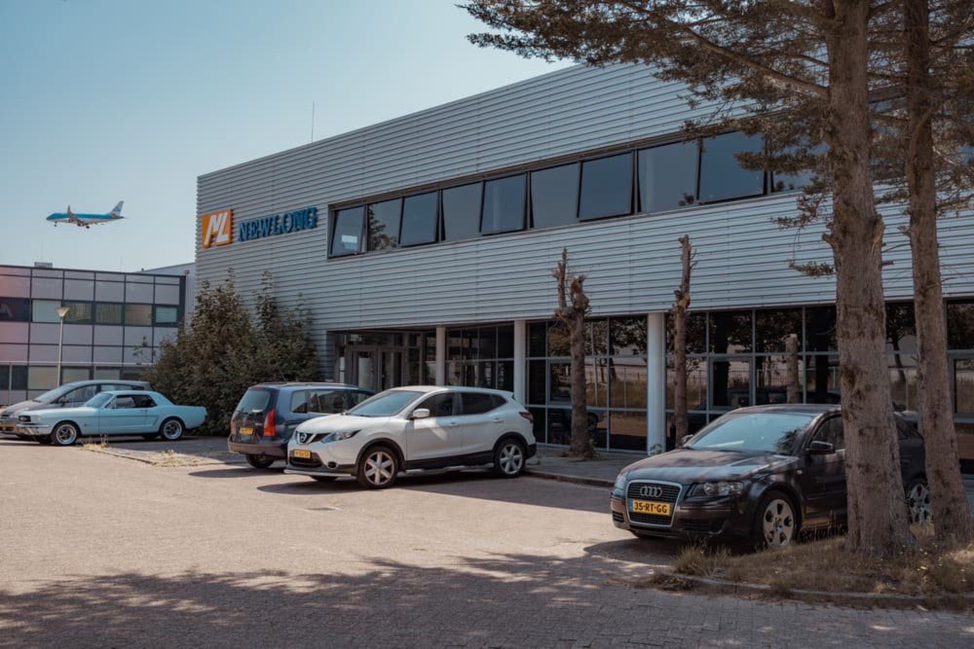 Newlong Holland HQ met overvliegend vliegtuig